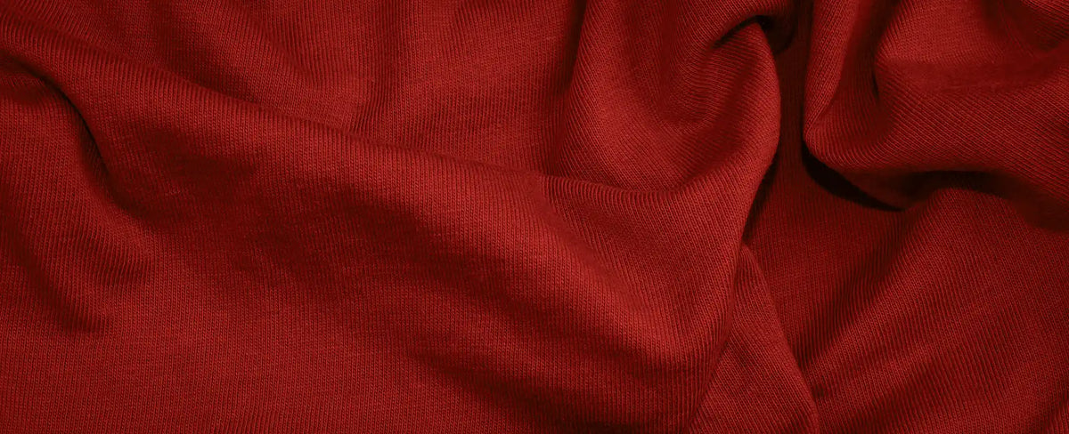 Strukturierte Oberfläche eines roten Stoffes mit sichtbaren Falten